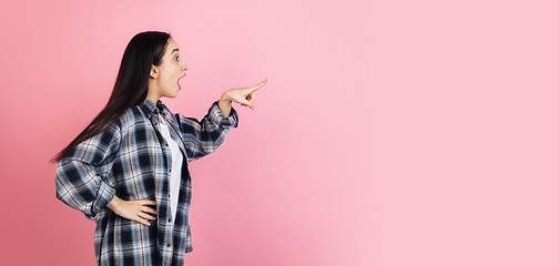 Image showing Caucasian woman\'s portrait isolated on coral pink studio background with copyspace