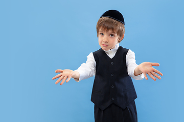 Image showing Portrait of a young orthodox jewish boy isolated on blue studio background, meeting the Passover