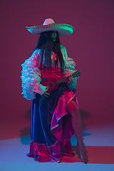 Image showing Fabulous Cinco de Mayo female dancer on purple studio background in neon light