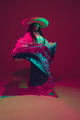 Image showing Fabulous Cinco de Mayo female dancer on purple studio background in neon light