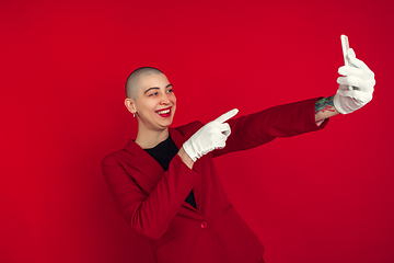 Image showing Portrait of young caucasian bald woman on red background