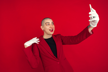 Image showing Portrait of young caucasian bald woman on red background