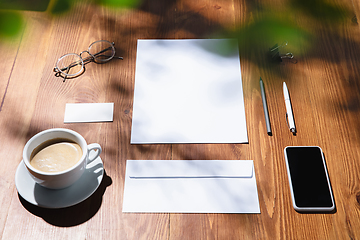 Image showing Creative and cozy workplace at home office, inspirational mock up with plant shadows on table surface