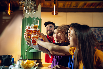 Image showing Sport fans cheering at bar, pub and drinking beer while championship, competition is going