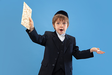 Image showing Portrait of a young orthodox jewish boy isolated on blue studio background, meeting the Passover