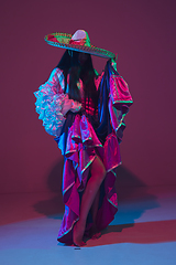 Image showing Fabulous Cinco de Mayo female dancer on purple studio background in neon light