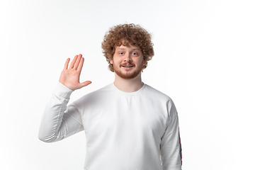 Image showing How coronavirus changed our lives. Young man greeting on white background