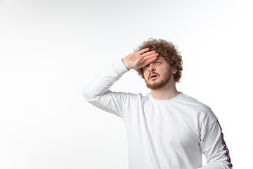 Image showing How coronavirus changed our lives. Young man taking temperature on white background