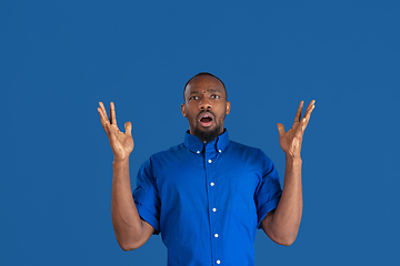 Image showing Monochrome portrait of young african-american man on blue studio background