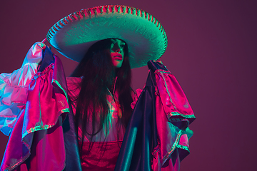 Image showing Fabulous Cinco de Mayo female dancer on purple studio background in neon light