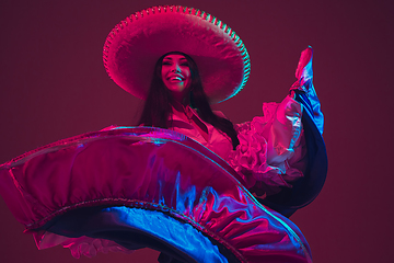 Image showing Fabulous Cinco de Mayo female dancer on purple studio background in neon light