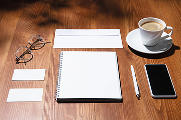 Image showing Creative and cozy workplace at home office, inspirational mock up with plant shadows on table surface