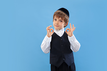 Image showing Portrait of a young orthodox jewish boy isolated on blue studio background, meeting the Passover