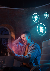 Image showing Shocked, upset and sad man using gadgets to get information of coronavirus pandemic spread
