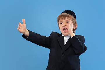 Image showing Portrait of a young orthodox jewish boy isolated on blue studio background, meeting the Passover