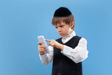 Image showing Portrait of a young orthodox jewish boy isolated on blue studio background, meeting the Passover