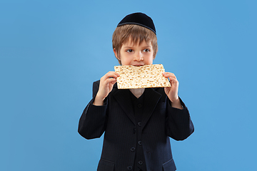 Image showing Portrait of a young orthodox jewish boy isolated on blue studio background, meeting the Passover