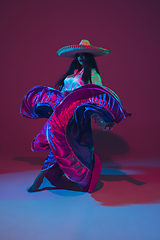 Image showing Fabulous Cinco de Mayo female dancer on purple studio background in neon light