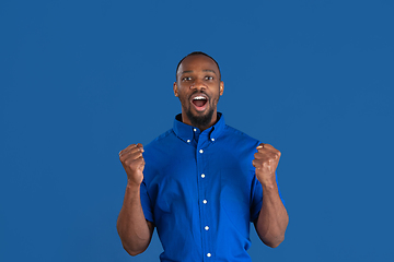 Image showing Monochrome portrait of young african-american man on blue studio background