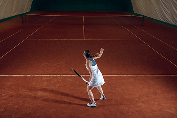 Image showing Young caucasian professional sportswoman playing tennis on sport court background