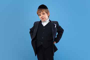 Image showing Portrait of a young orthodox jewish boy isolated on blue studio background, meeting the Passover