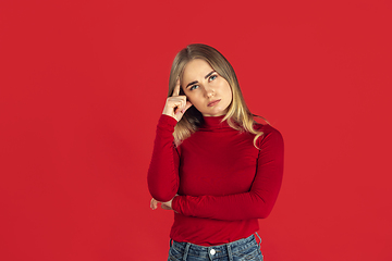 Image showing Monochrome portrait of young caucasian blonde woman on red background