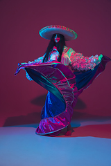 Image showing Fabulous Cinco de Mayo female dancer on purple studio background in neon light