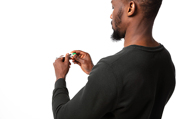 Image showing How coronavirus changed our lives. Young man checking, taking temperature on white background