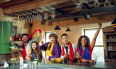 Image showing Sport fans cheering at bar, pub and drinking beer while championship, competition is going