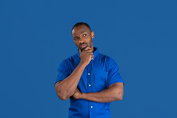 Image showing Monochrome portrait of young african-american man on blue studio background