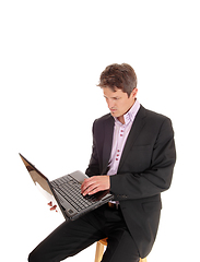 Image showing Business man sitting and working on his laptop