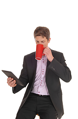 Image showing Business man drinking his coffee in a suit
