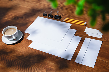 Image showing Creative and cozy workplace at home office, inspirational mock up with plant shadows on table surface