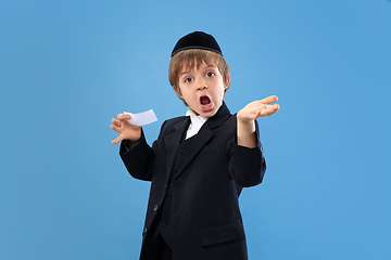 Image showing Portrait of a young orthodox jewish boy isolated on blue studio background, meeting the Passover