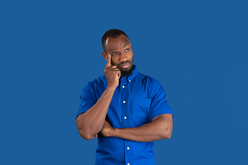 Image showing Monochrome portrait of young african-american man on blue studio background