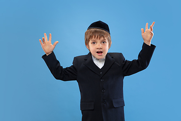 Image showing Portrait of a young orthodox jewish boy isolated on blue studio background, meeting the Passover