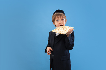 Image showing Portrait of a young orthodox jewish boy isolated on blue studio background, meeting the Passover