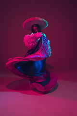 Image showing Fabulous Cinco de Mayo female dancer on purple studio background in neon light