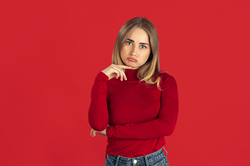 Image showing Monochrome portrait of young caucasian blonde woman on red background