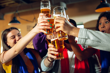 Image showing Sport fans cheering at bar, pub and drinking beer while championship, competition is going