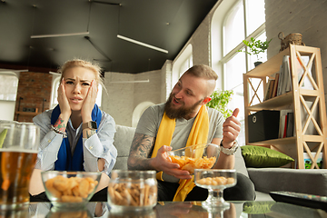 Image showing Excited family watching football, sport match at home, beautiful couple