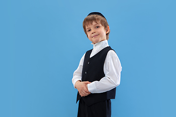 Image showing Portrait of a young orthodox jewish boy isolated on blue studio background, meeting the Passover