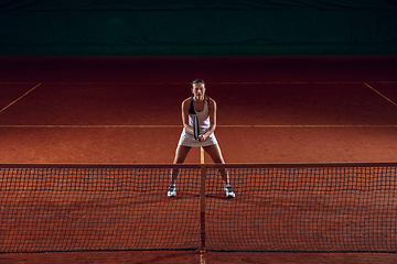 Image showing Young caucasian professional sportswoman playing tennis on sport court background