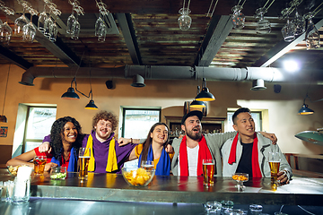 Image showing Sport fans cheering at bar, pub and drinking beer while championship, competition is going