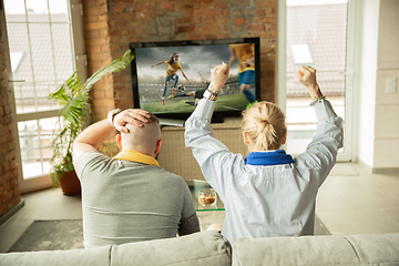 Image showing Excited family watching female football, sport match at home, beautiful couple