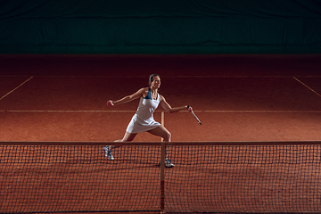 Image showing Young caucasian professional sportswoman playing tennis on sport court background