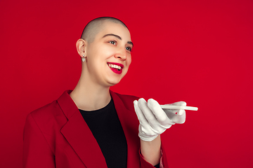 Image showing Portrait of young caucasian bald woman on red background