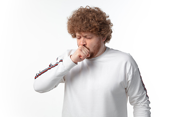 Image showing How coronavirus changed our lives. Young man coughing on white background