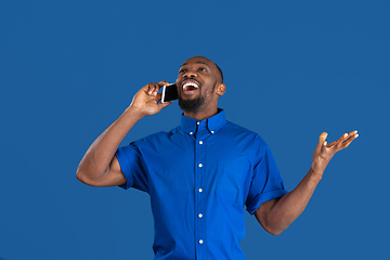 Image showing Monochrome portrait of young african-american man on blue studio background