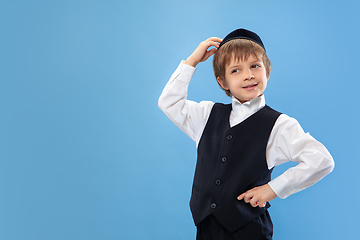 Image showing Portrait of a young orthodox jewish boy isolated on blue studio background, meeting the Passover